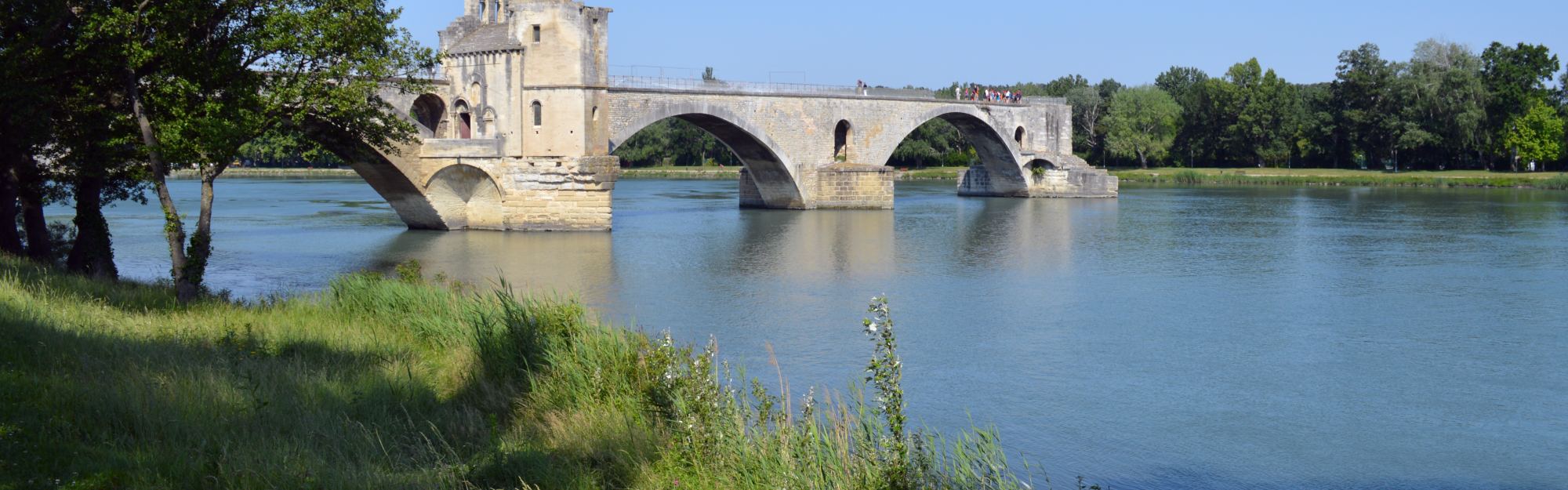 The four surviving arches of the Pont Saint-Bénézet reaching out from the Avignon bank and stopping short in the middle of the Rhône.